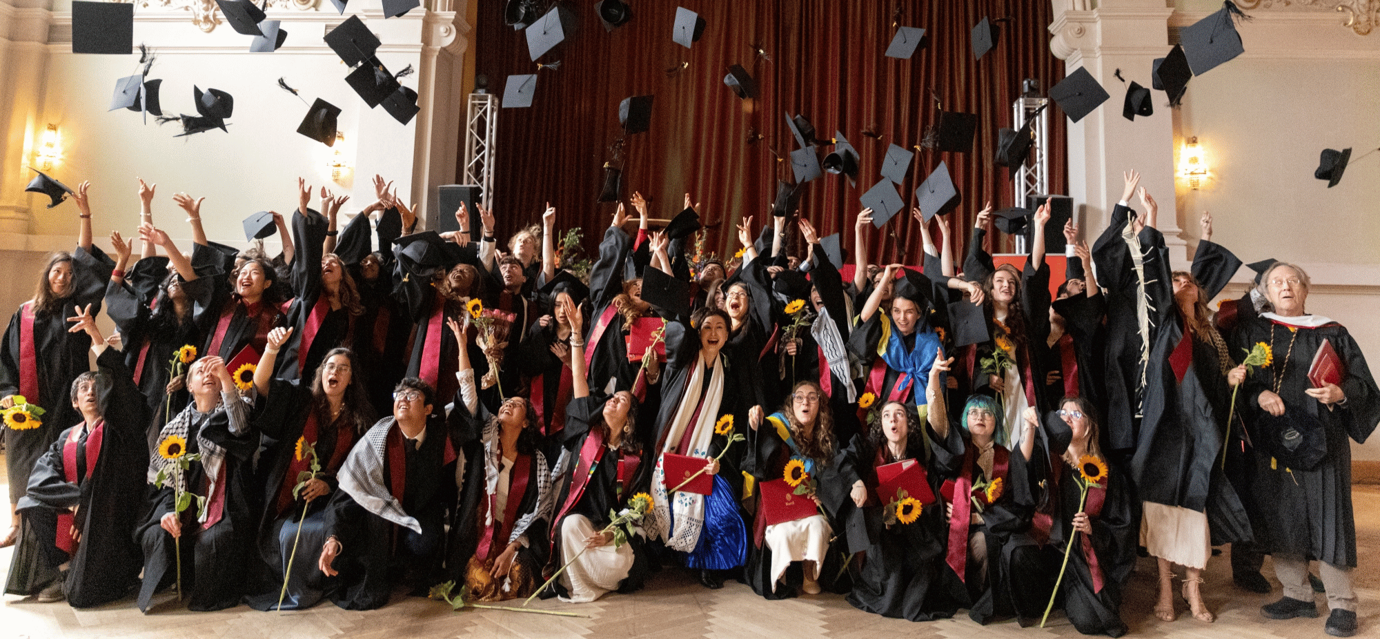 The graduating class throws their caps into the air in celebration. 